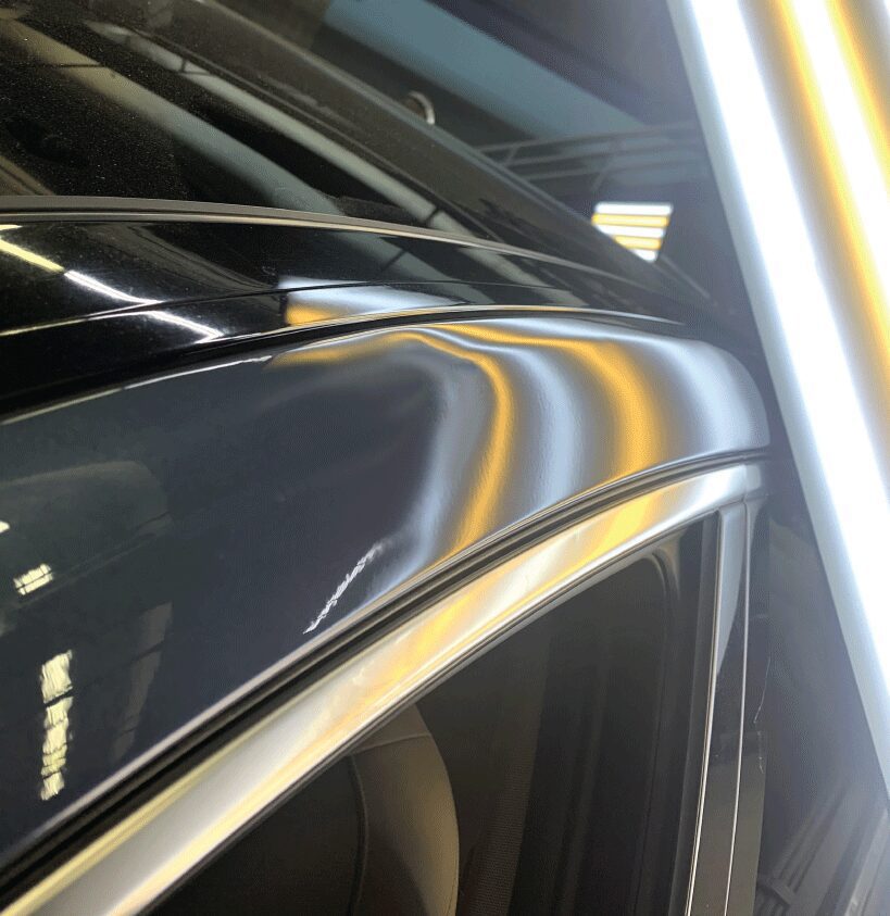 A removed dent on the outer top pillar of a car as part of a before and after slider